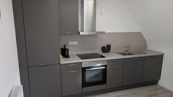 Een koelkast, een oven, een kookplaat, een vaatwasser