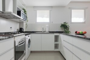 Appartement (B) | Privékeuken | Een koelkast met diepvriezer, een microgolfoven, een oven, een kookplaat