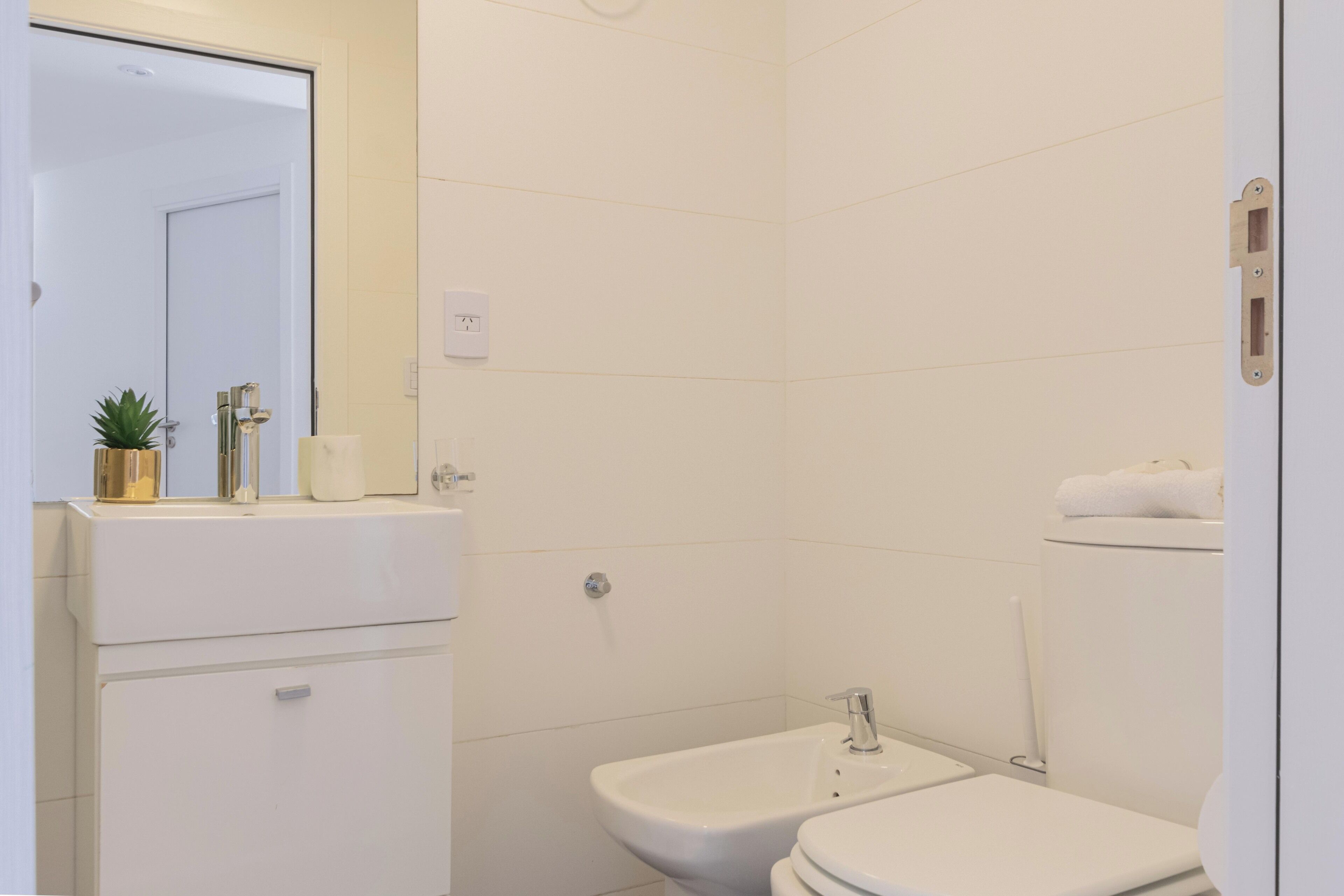 A bathroom with a sink, mirror, and toilet.