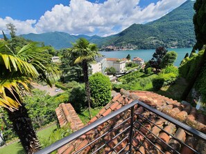 Une terrasse offrant une vue sur un lac, des montagnes et une ville.