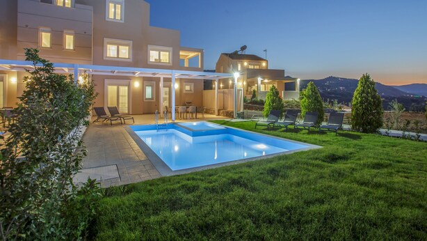 Ein modernes Haus mit Swimmingpool, Sitzgelegenheit im Freien und Blick auf die Hügel.