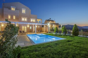 A modern house with a swimming pool, outdoor seating, and a view of the hills. - Blue Hills Villas by Estia Red 2 (Malevizi)