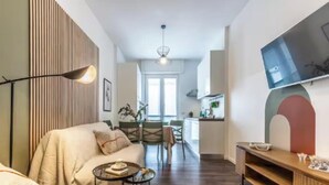 Un salon moderne avec un canapé, une table basse et un téléviseur fixé au mur.