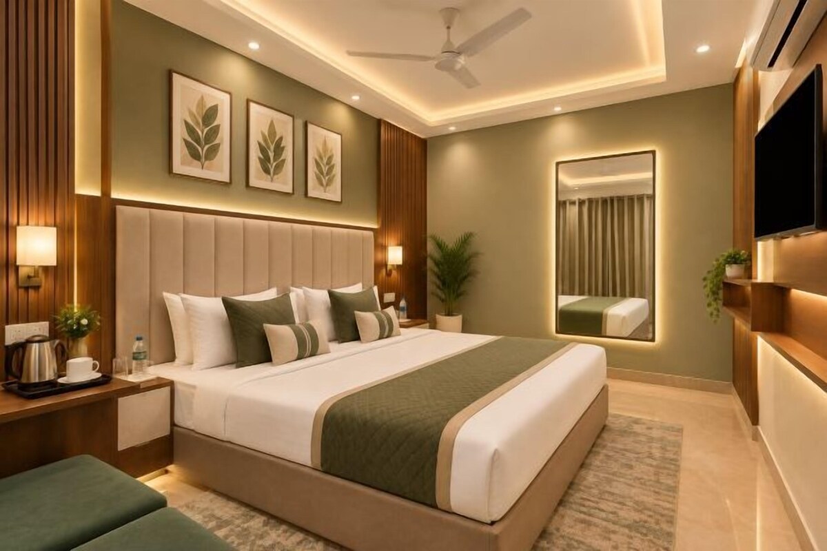A modern hotel room with a large bed, bedside tables, a flat-screen TV, and a ceiling fan.