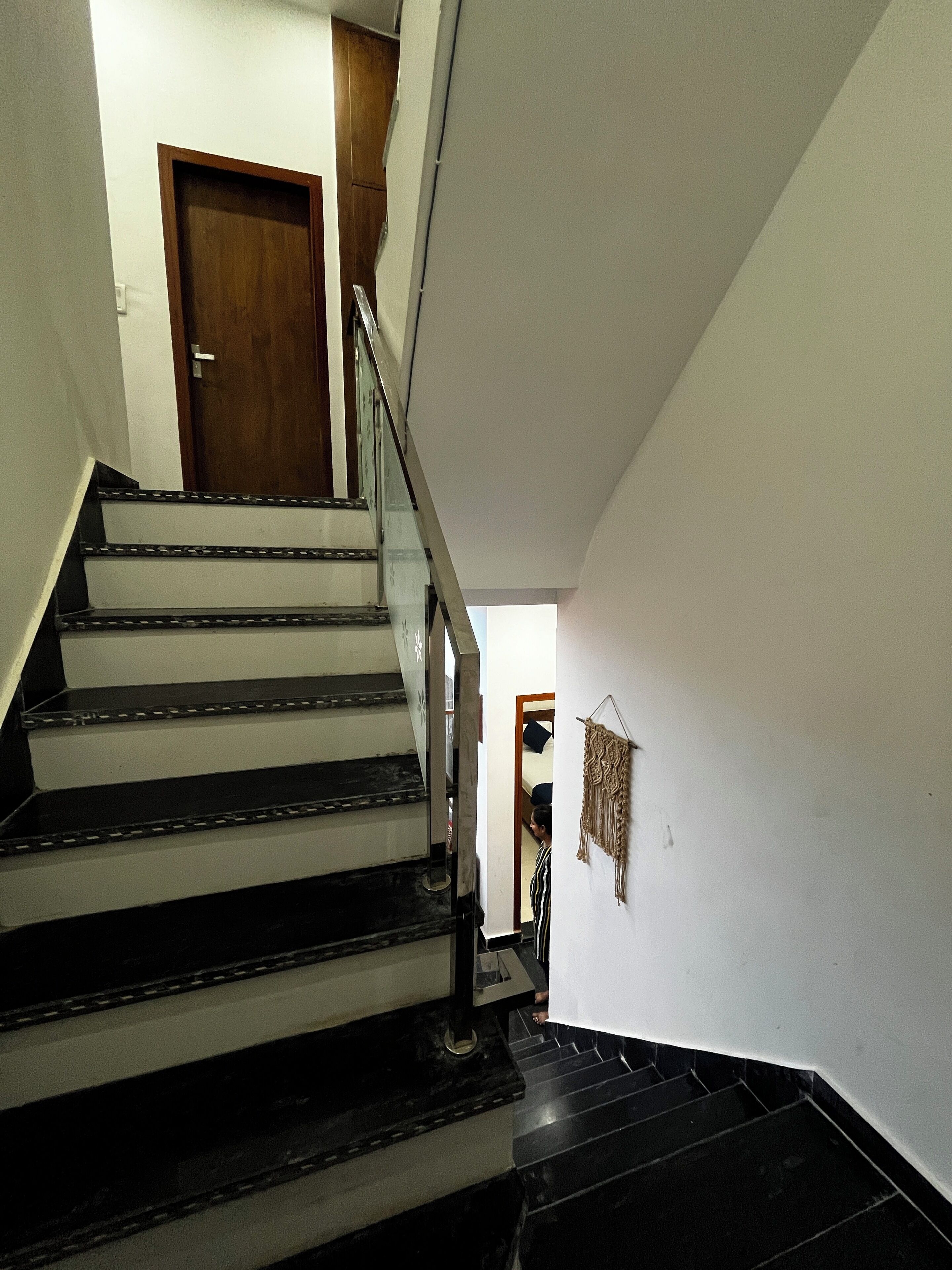 A staircase with black steps and a wooden door at the top.