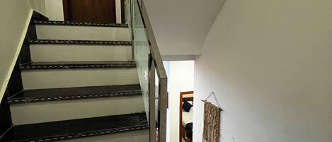 A staircase with black steps and a wooden door at the top.