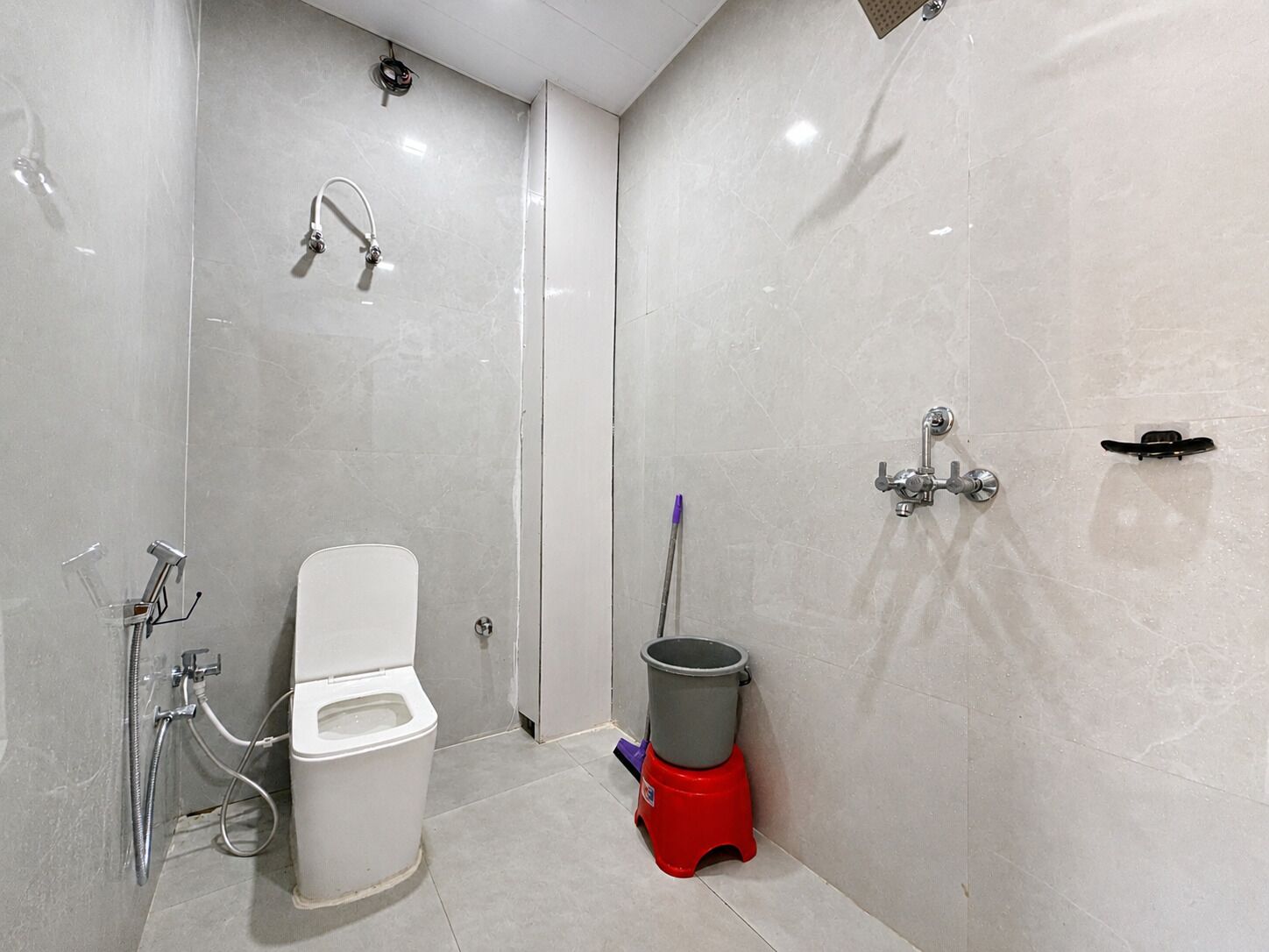 A bathroom with a toilet, a shower, and a bidet.