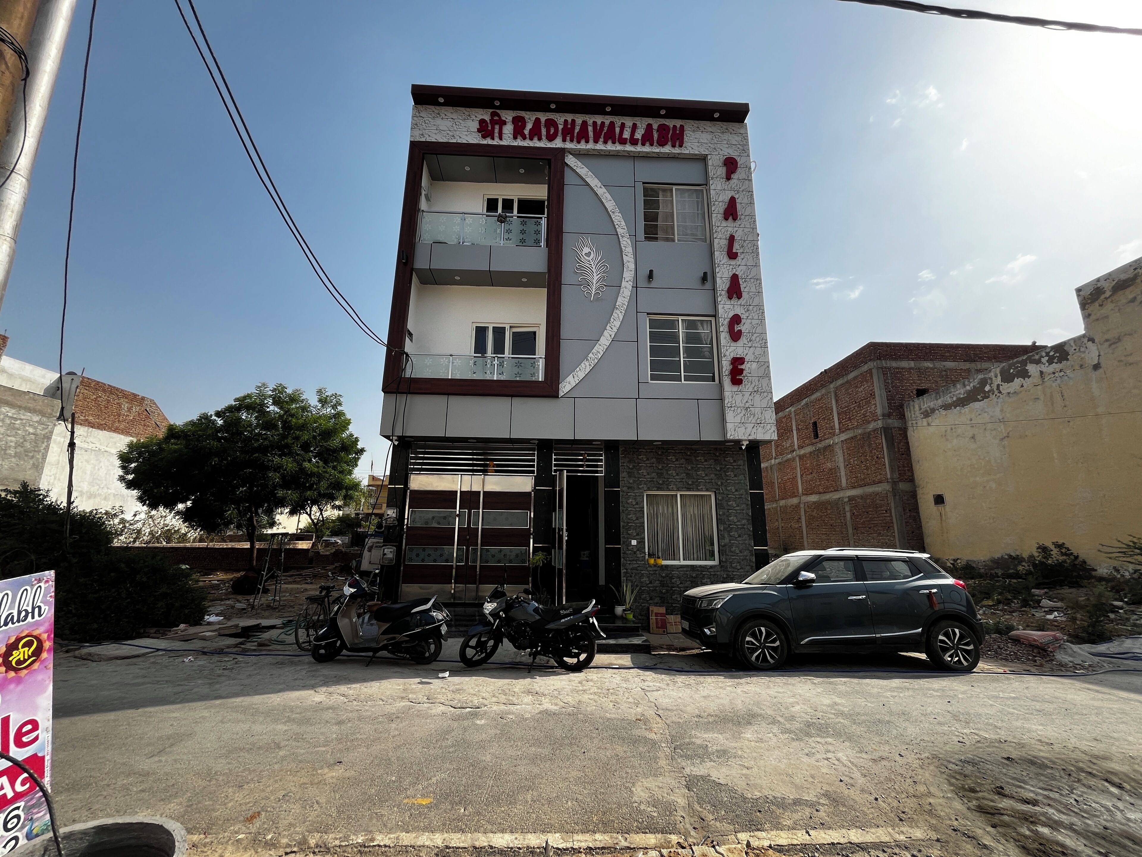A multi-story building with a sign reading "RADHAVALLABH PALACE".
