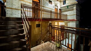 A multi-level building with a wooden staircase and balcony railing. - Crystal Mountain Jibhi (Banjar)