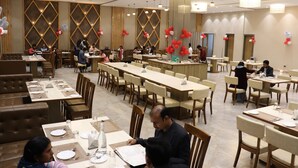 A spacious dining area with multiple tables and booths, equipped with chairs and tables set for dining.