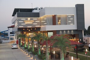 A modern hotel with a prominent sign, outdoor seating, and a well-lit entrance. - shivanta hotel & resorts (Jhunjhunu)
