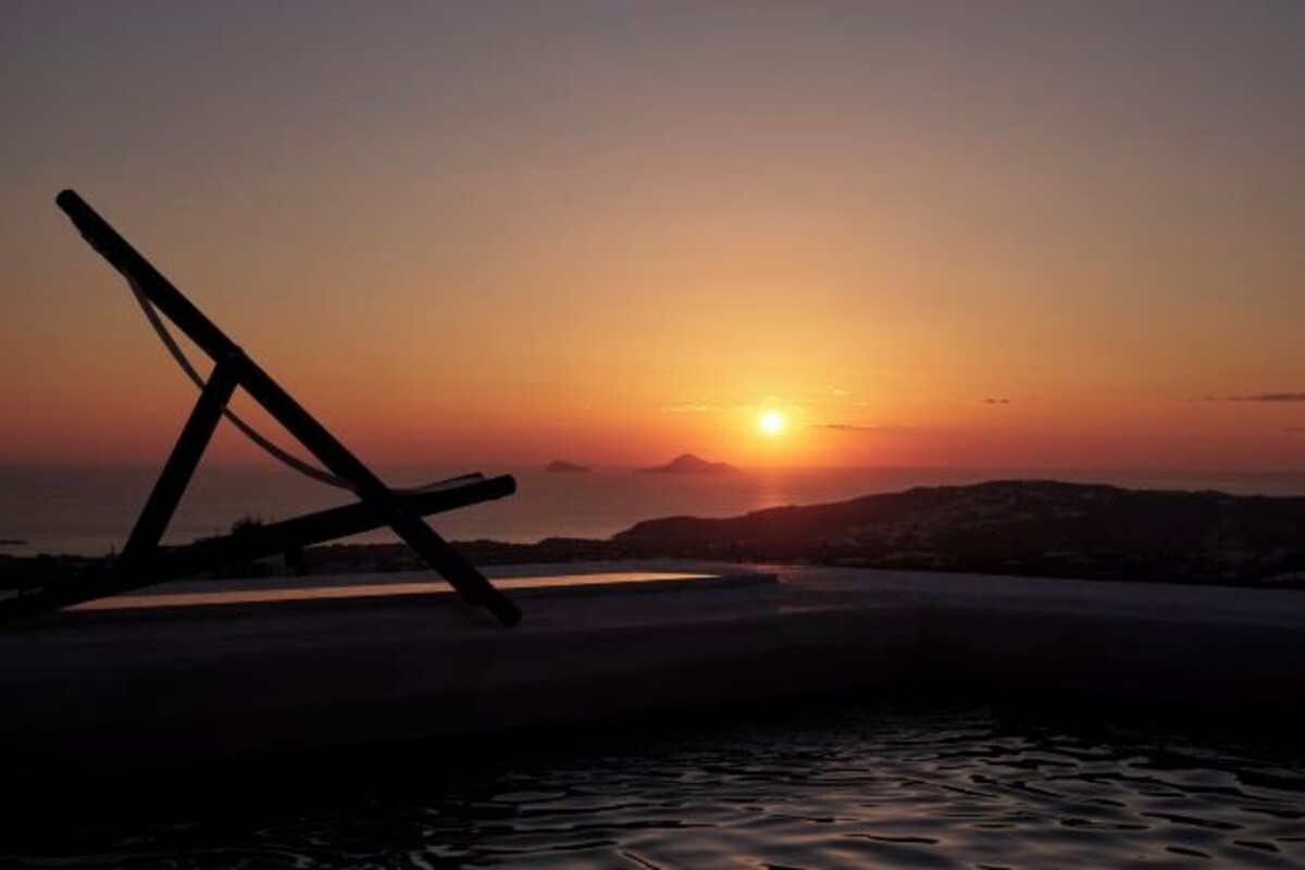 A sunset over water with a silhouette of a structure.