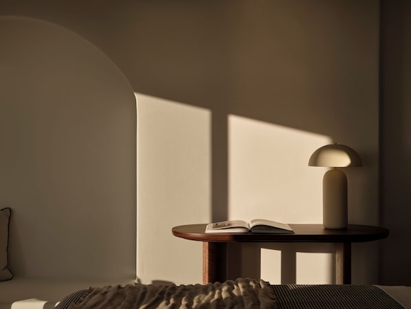 A reading area with a lamp, a book, and a patterned rug.