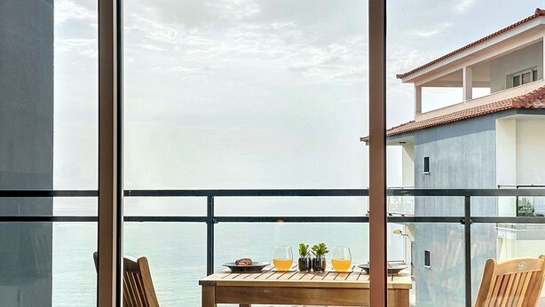 Un balcone con un tavolo apparecchiato per due, con vista sulla costa.