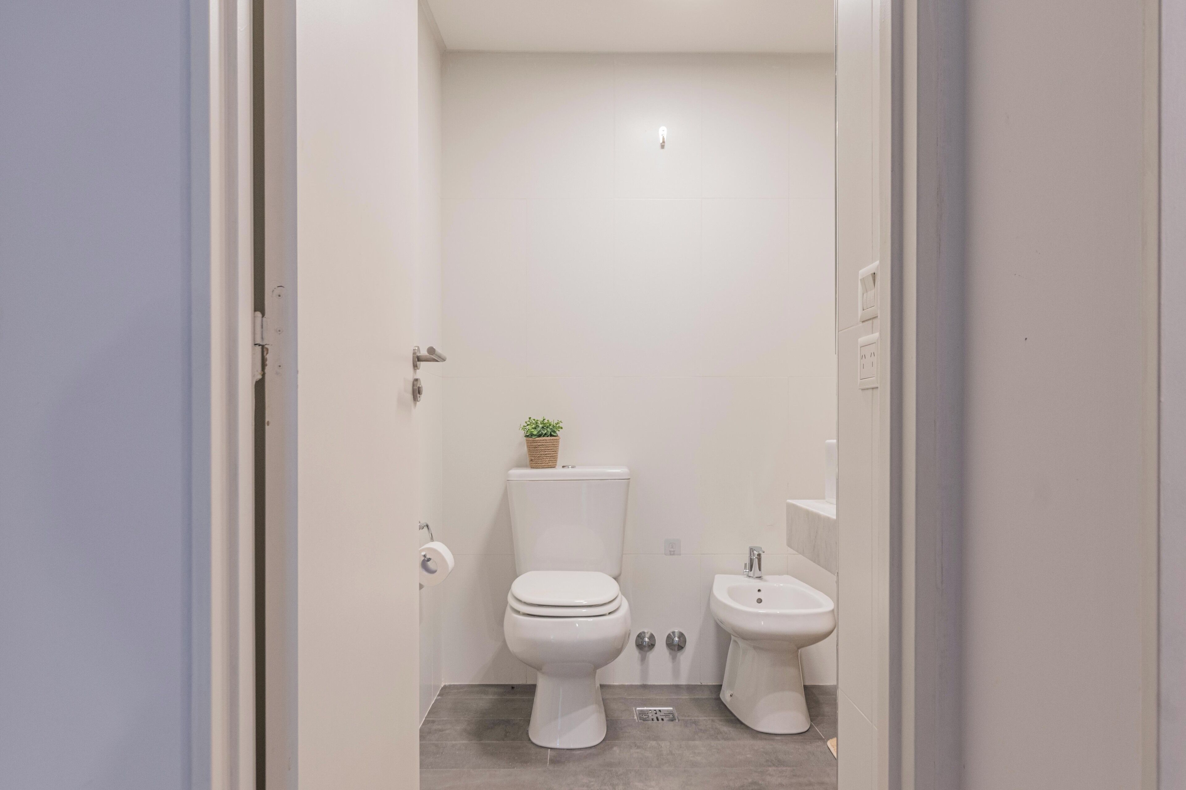Un bagno piccolo e pulito con toilette, bidet e lavandino.
