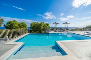 A rectangular swimming pool with clear blue water, surrounded by a tiled deck and a metal fence. - Villa Niki With Swimming Pool (Kefalonia)