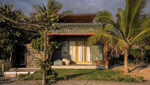 A house with a stone facade, large windows, and a covered porch. - Samas Hotel - La Saladita (Saladita)