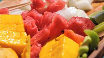 Una bandeja de madera con frutas y verduras diversas.