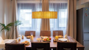 Een eetgedeelte met een houten tafel gedekt voor het ontbijt, inclusief borden, glazen en een wafel.