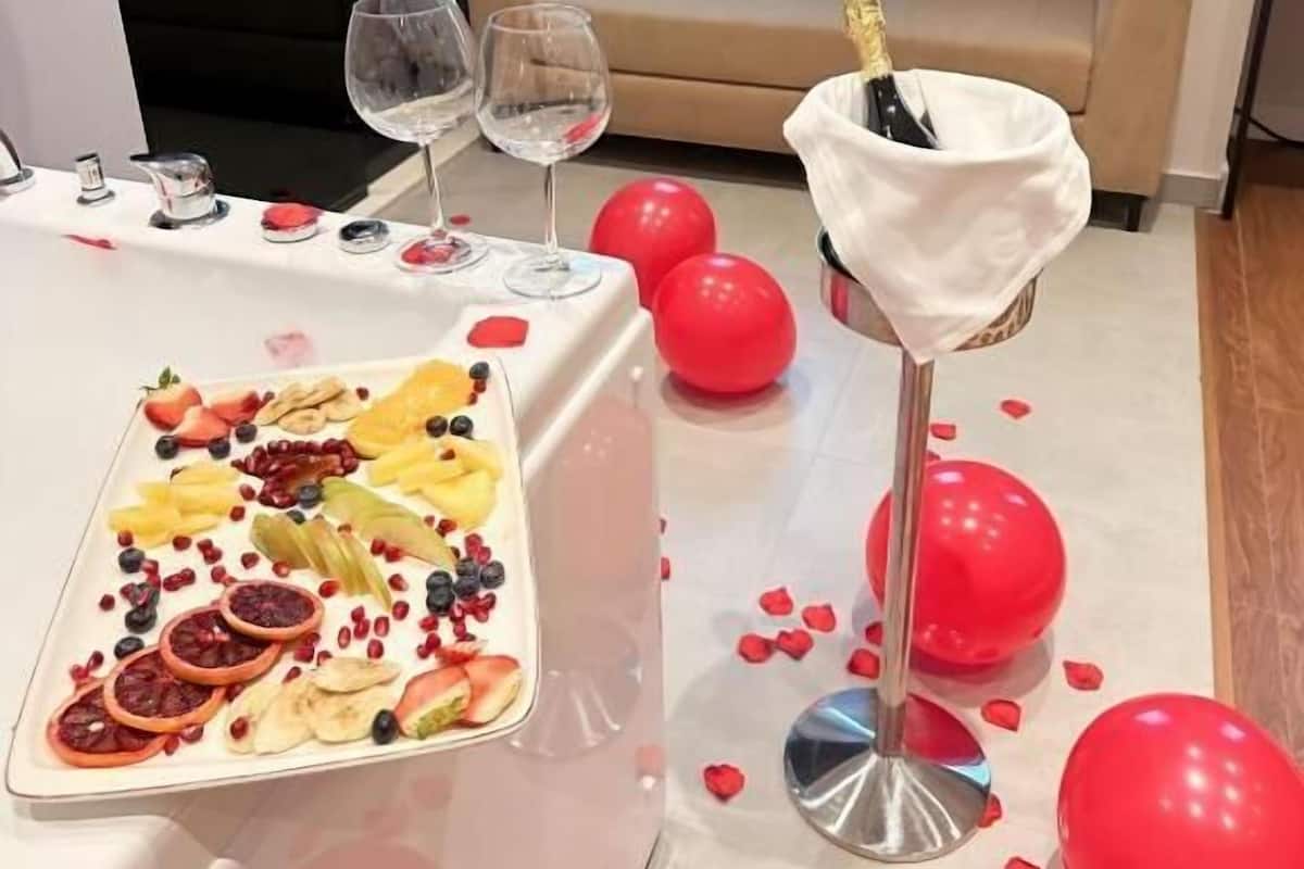Une pièce avec une table mise pour un repas, un canapé et une fenêtre avec des rideaux.