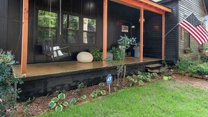 A porch with a swing chair, a bench, and a potted plant. - Midnight Sanctuary at Mystic Falls - 3 Bed 2.5 BA Home 1 mi to Covington Square (Covington)