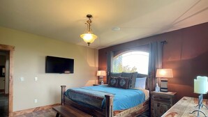A bedroom with a wooden bed, two bedside tables, a bench, a TV mounted on the wall, and a window with curtains. - Spacious 5-bedroom house in beautiful Belgrade with WiFi (Belgrade)