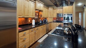A modern kitchen with wooden cabinets, stainless steel appliances, and a granite countertop. - Spacious 5-bedroom house in beautiful Belgrade with WiFi (Belgrade)