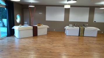 Ein geräumiges Zimmer mit zwei Empfangstheken, Holzboden und großen Fenstern.