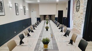 A long conference table with chairs, glassware, and black napkins.