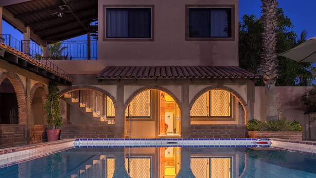 A two-story house with a swimming pool in front. - 7bdrm  boutique hotel with AC, WiFi , heated pool convenient location. (Loreto)