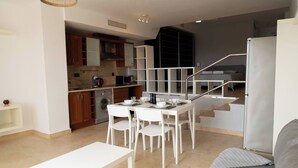A modern apartment with a dining area, kitchen, and living space. - La Envia Golf Suite (Vícar)