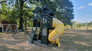 Een speeltuin met een glijbaan en een klimmuur.
