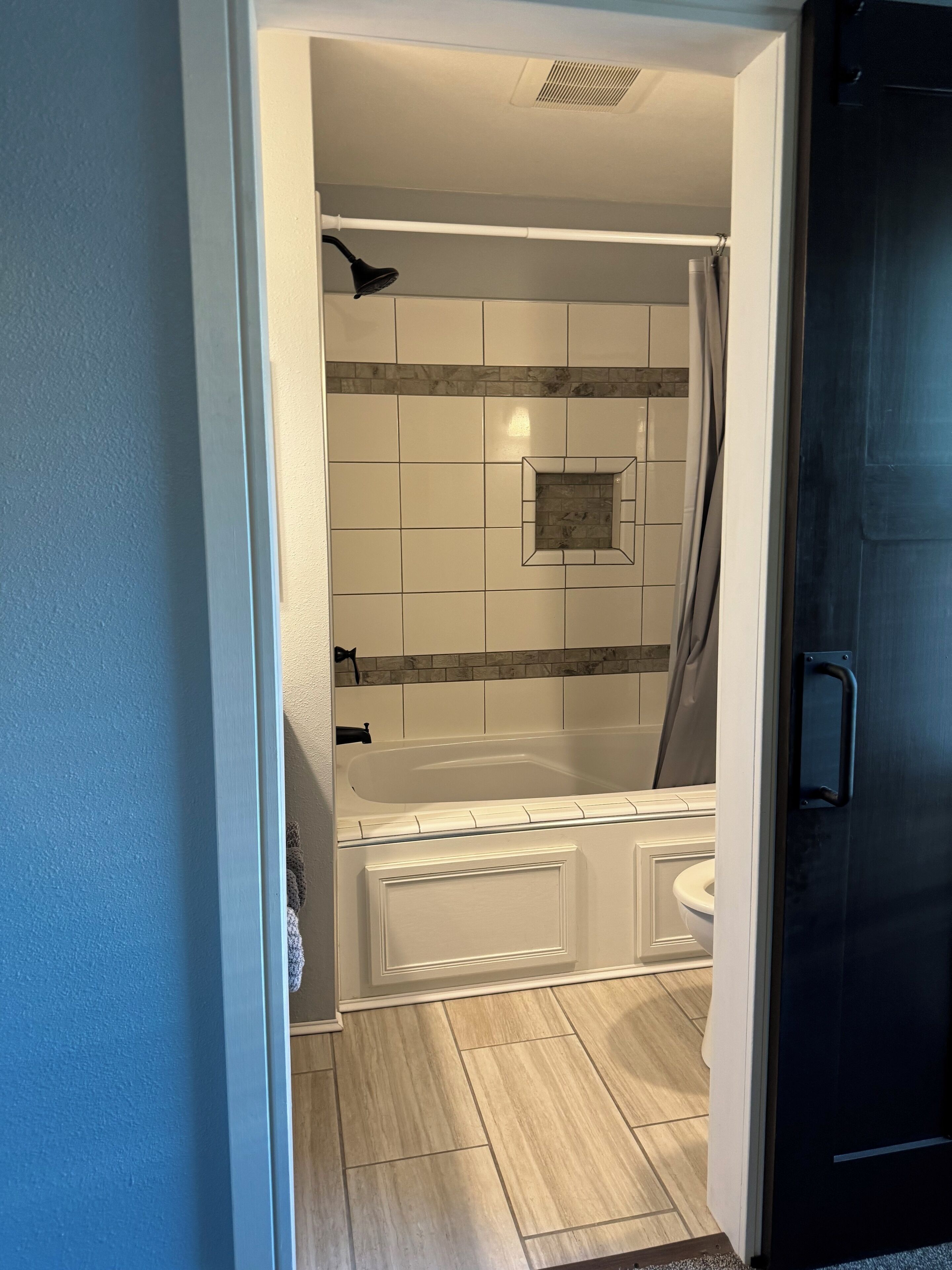 A bathroom with a bathtub, shower, and toilet.