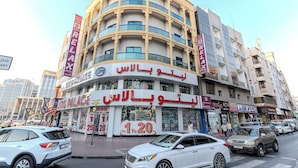 A multi-story building with a curved facade, featuring a prominent sign for "Auto Palace" and "Relax" on the upper levels. - City Relax Hotel (Dubai)