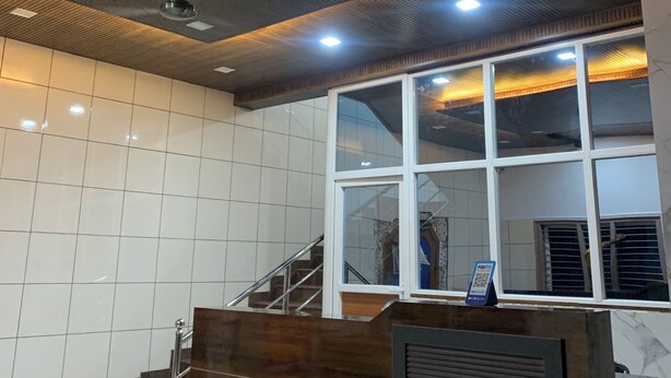 Un interior moderno con techo de madera, un mostrador de recepción y una escalera.