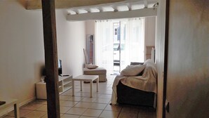 Ein Hotelzimmer mit Bett, kleinem Tisch, Stuhl und Fernseher.