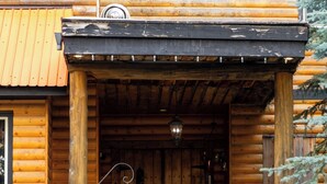 A wooden log cabin with a sign reading "OFFICE" above the entrance. - Rams Head Inn (Rossland)