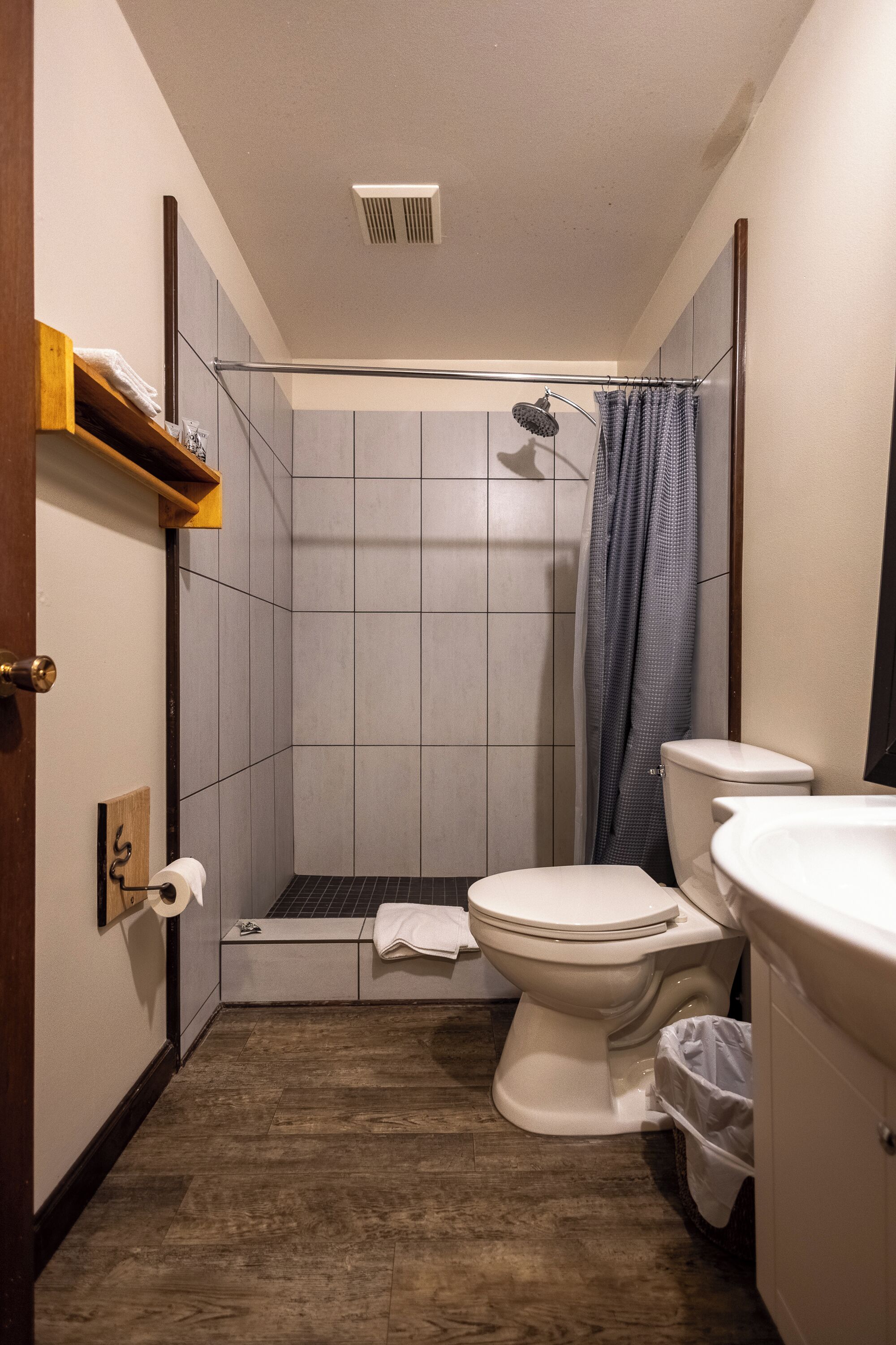 A compact bathroom with a shower, toilet, and sink.