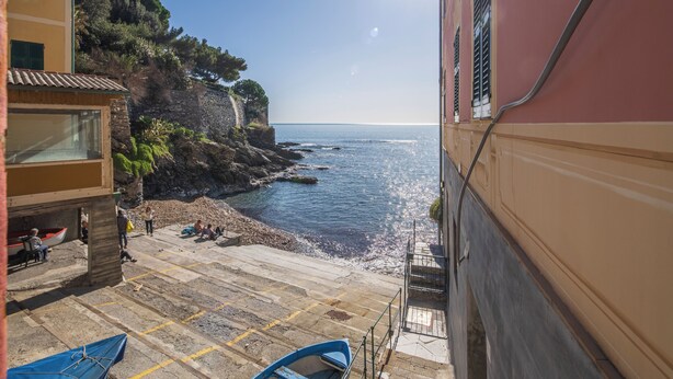 A coastal building with a stone staircase leading to a beach. - Green Home Seaside Parking  Wifi Ac Genova (Genoa)
