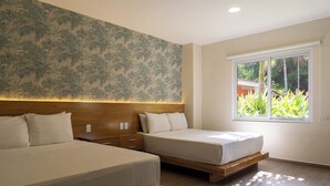 A hotel room with two beds, a wooden headboard, a large window with a view of greenery, and a wall with a leafy pattern. - El Pacifico (La Libertad)