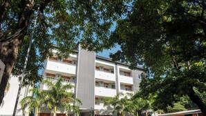 A multi-story building with balconies, surrounded by trees and greenery. - El Pacifico (La Libertad)