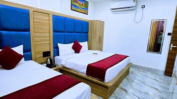 A hotel room with two beds, a wooden headboard, a marble floor, and an air conditioning unit.