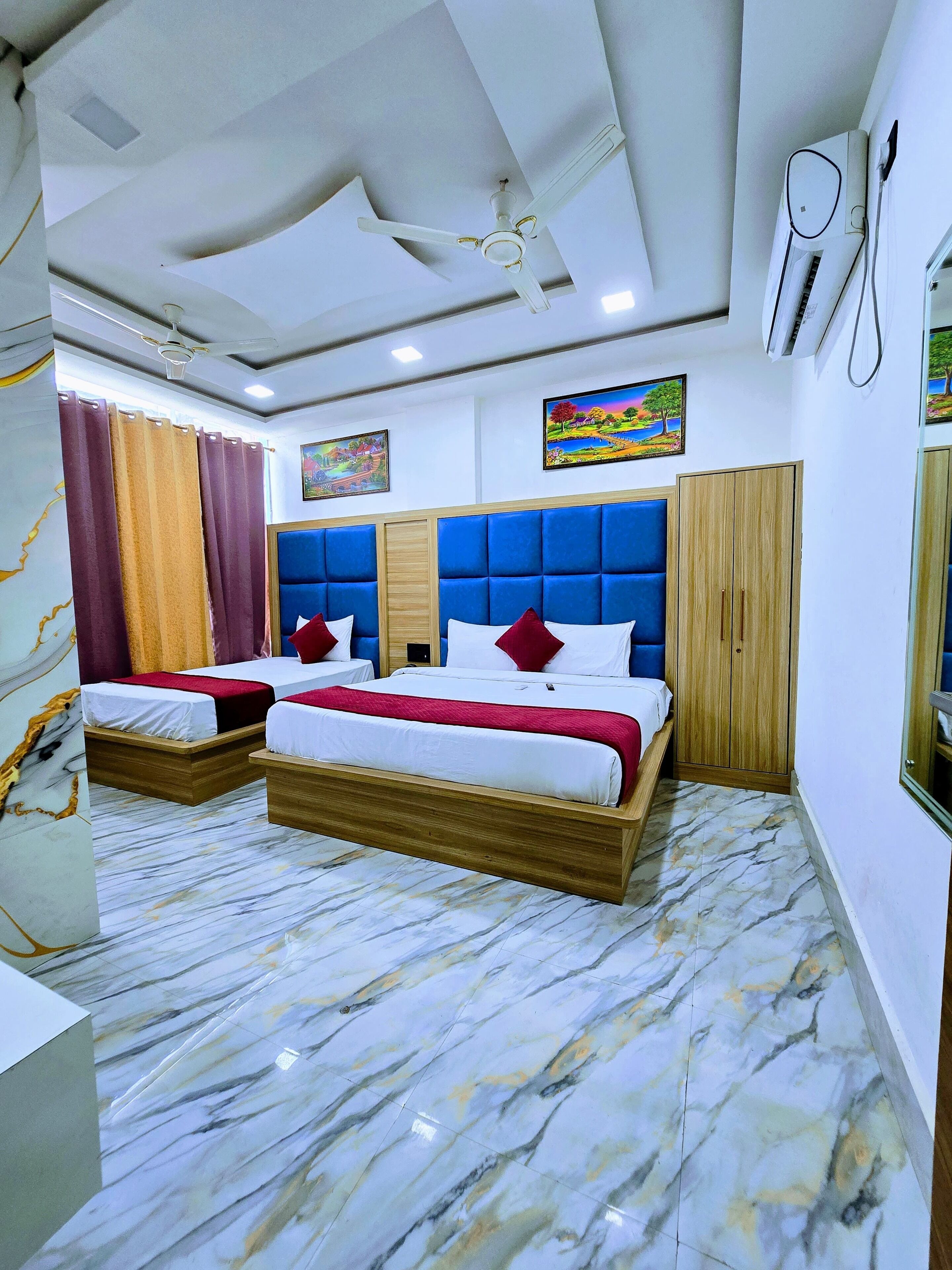 Une chambre d’hôtel avec deux lits, un ventilateur de plafond, un appareil de climatisation et un revêtement de sol en marbre.