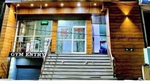 A building with a sign reading "AARAV GRAND PALACE" and a "GYM ENTRY" sign below. - Hotel Aaarav Grand - Mathura Vrindavan (Mathura)