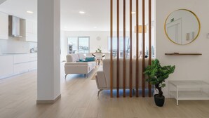A modern living room with a sofa, a dining table, and a potted plant. - Villa Bela Vista, beach villa with ocean view  (Atalaia)