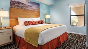 A hotel room with a bed, a nightstand, a lamp, and a window. - Worldmark Indio Resort/Coachella Week1/2BDR/Sleeps 6 (Indio)