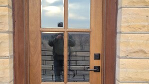 A wooden door with a glass panel and a metal handle. - Canyon Acres Ranch • Horse-Friendly Kansas Retreat (Russell)