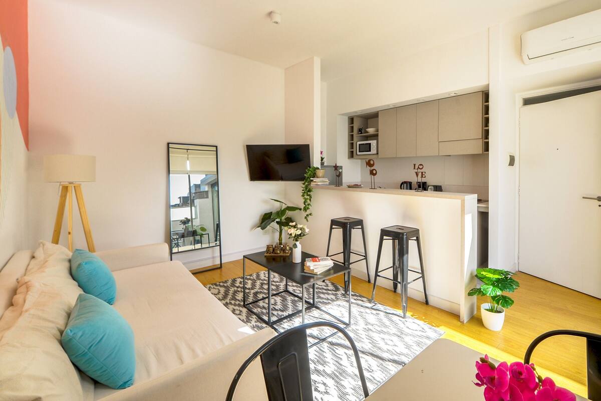Un apartamento moderno con sala de estar, cocina y comedor.
