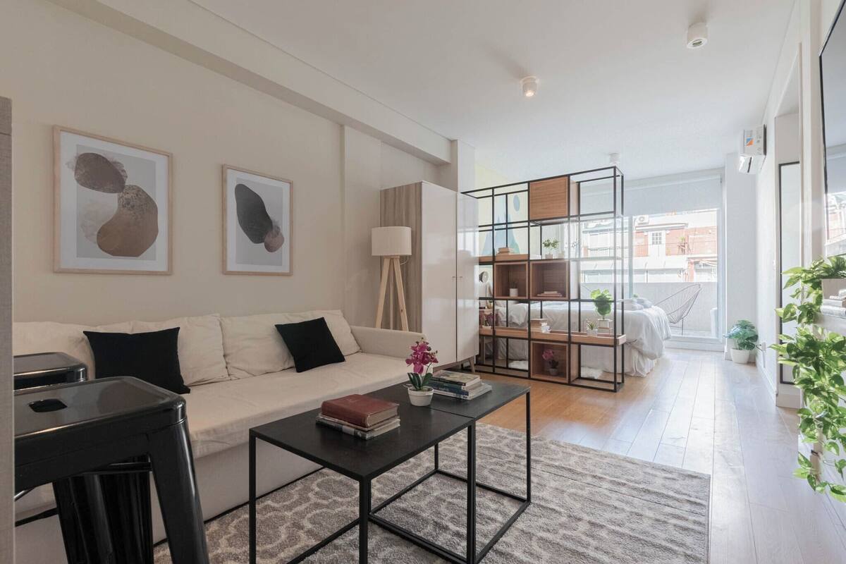 Una sala de estar moderna con un sofá, una mesa de centro y una estantería.