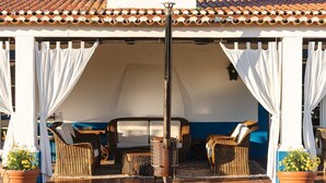 An outdoor seating area with wicker furniture, a metal table, and potted plants. - Charming Farm House With Pool (Ferreira do Alentejo)